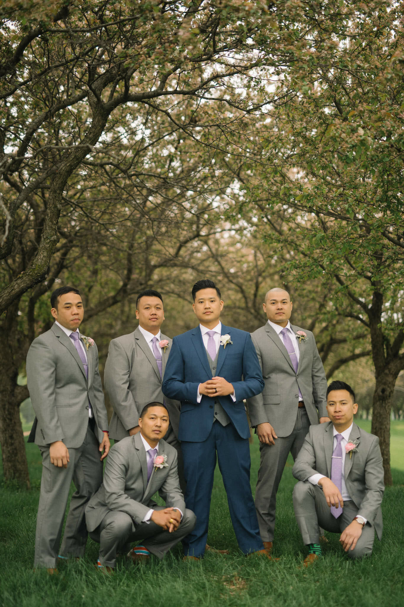 Groomsmen standing in a group of trees