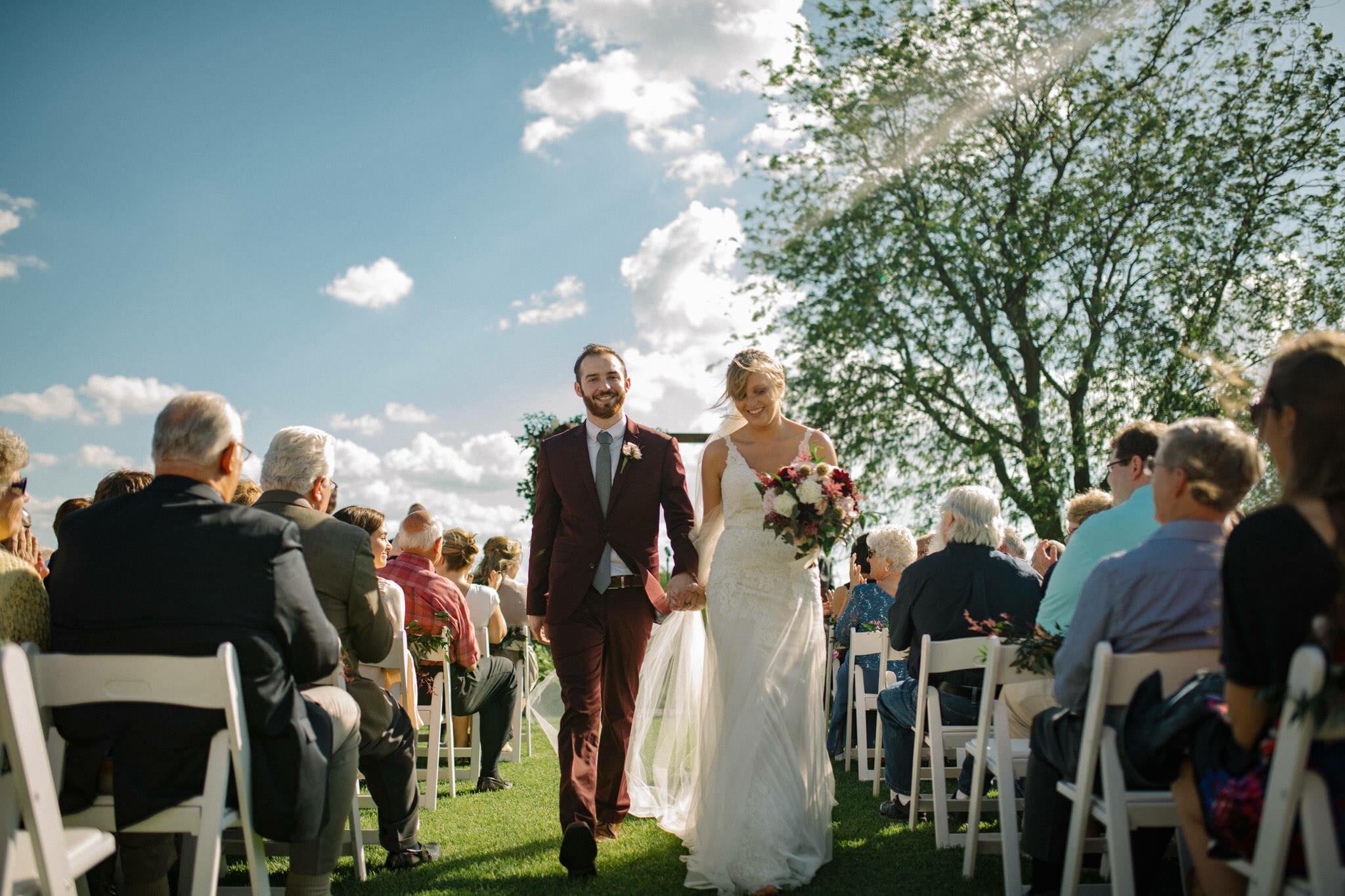 Couple walking out of ceremony at Glen Oaks Country Club, West Des Moines, Iowa