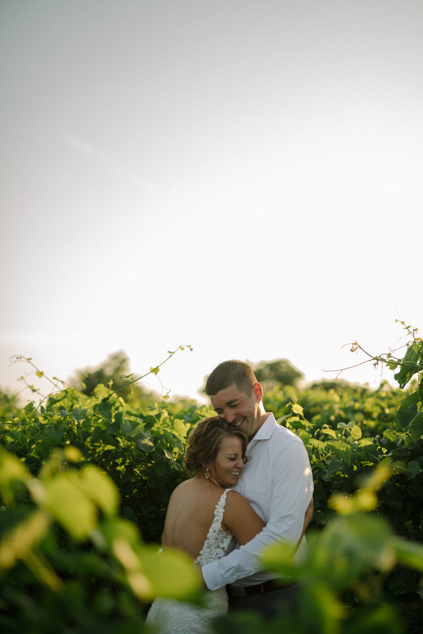 Couple hugging on wedding day in a vineyard