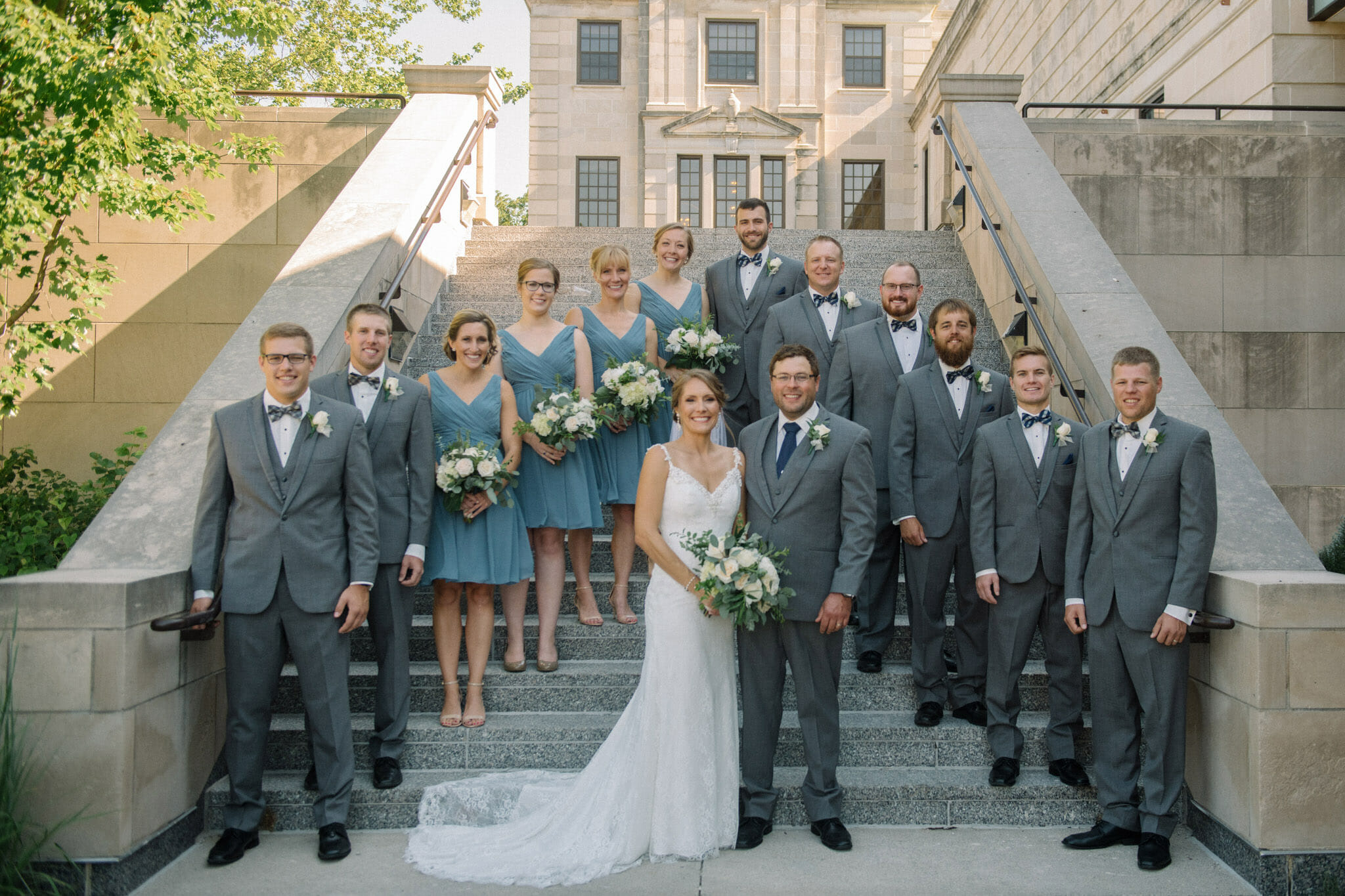 Wedding day couple and bridal party standing in front of the Memorial Union on the campus of Iowa State University in Ames, Iowa