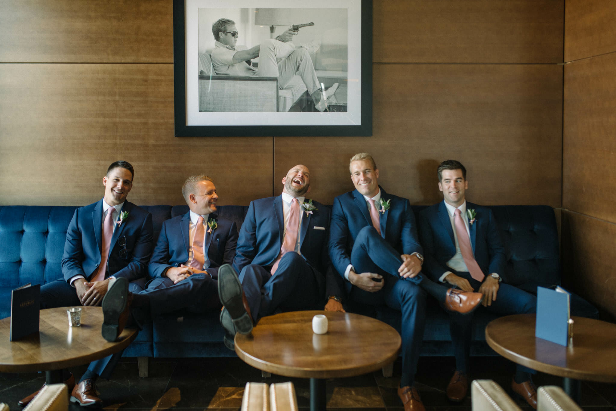 Group of groomsmen sitting on blue couches at the Republic on Grand in downtown Des Moines, Iowa