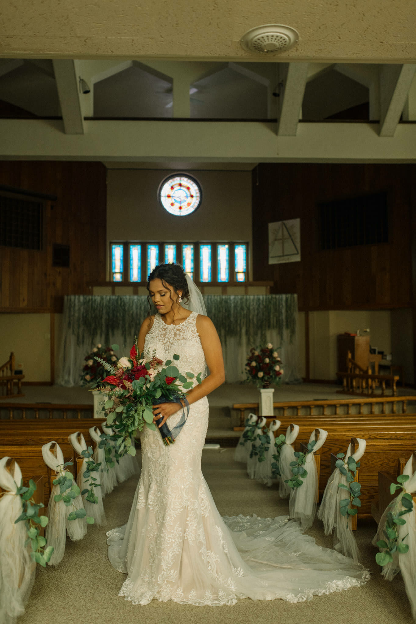 Serene bride standing in the aisle at a church in Eagle Grove, Iowa