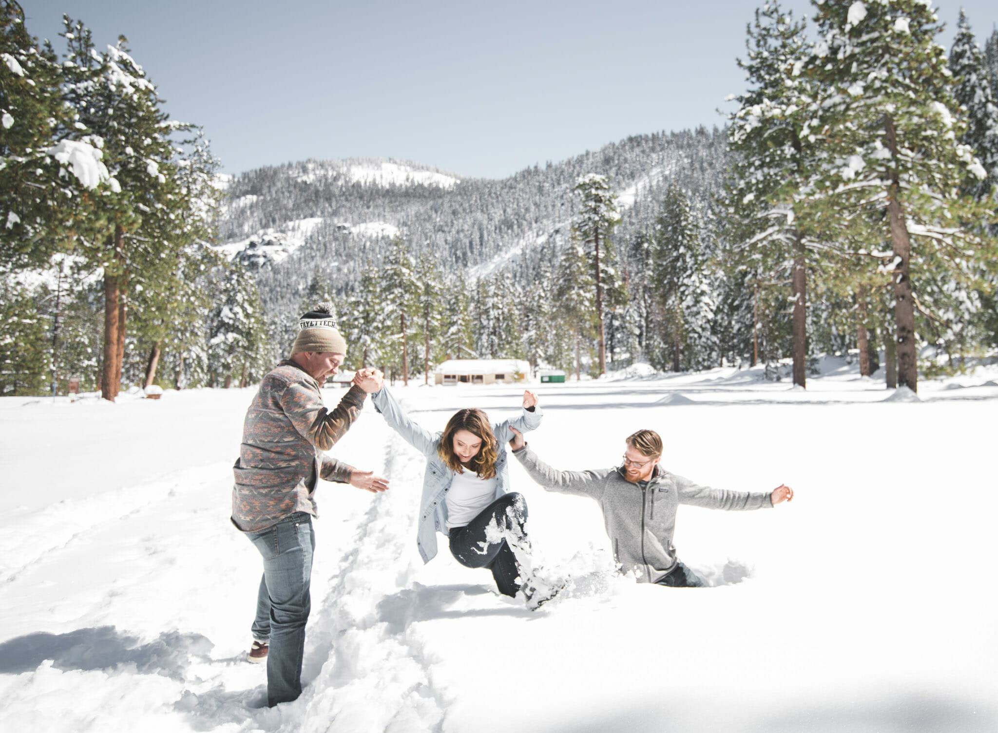 photographer helping couple out of deep snow in Sequoia National Forest