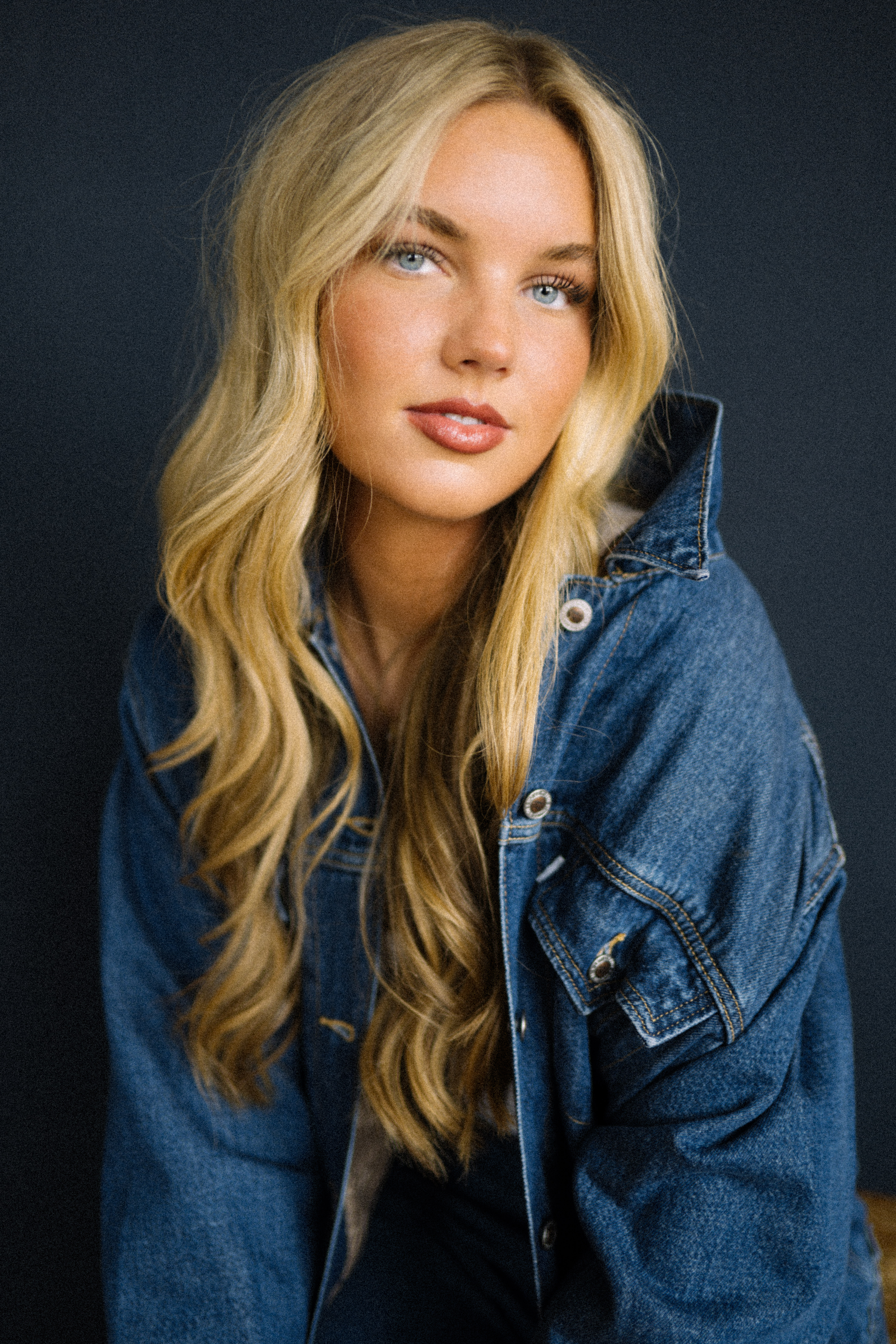 a woman with blonde hair wearing a denim jacket